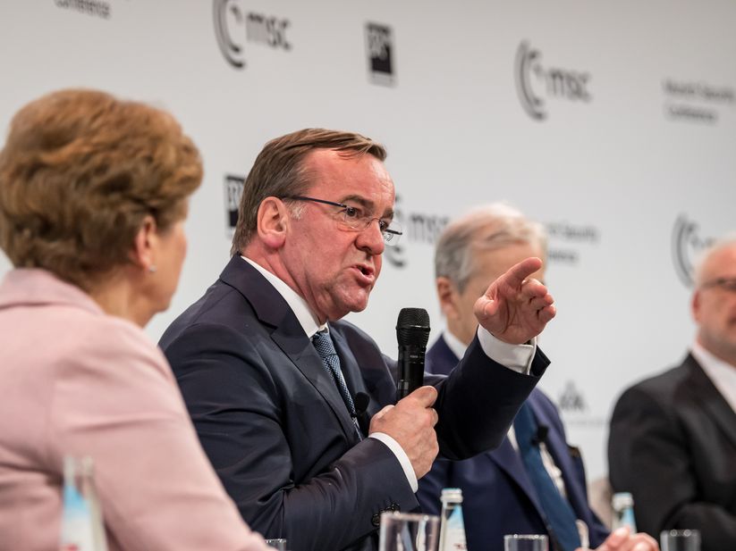 Boris Pistorius speaking into a microphone and pointing on a panel at the Munich Security Conference 2023