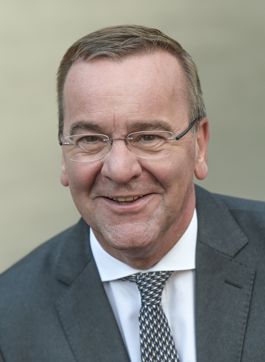 Portrait of Boris Pistorius smiling, in rimless glasses, grey suit and patterned tie, 2019